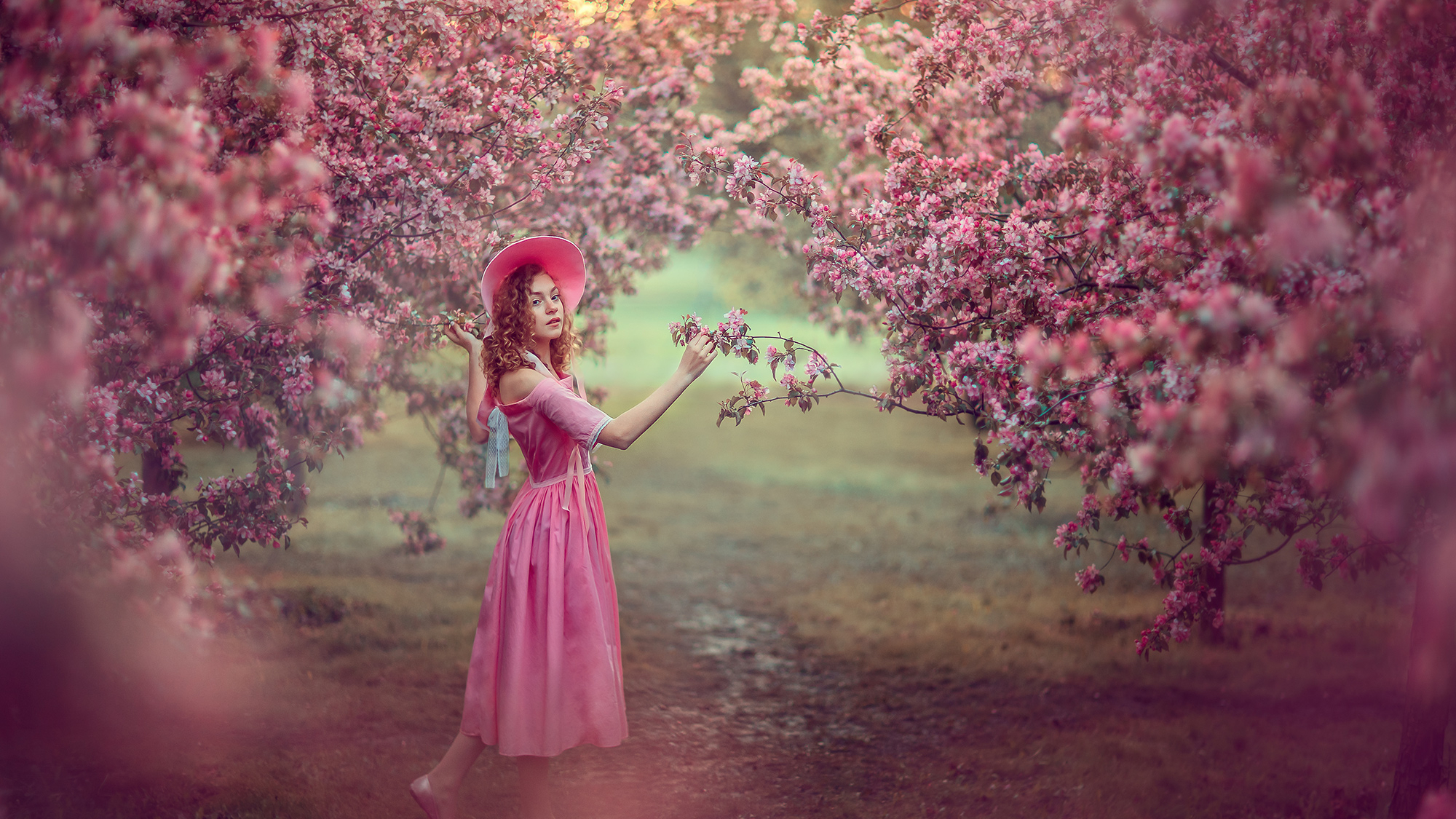 Девушка в розовом цветущем саду